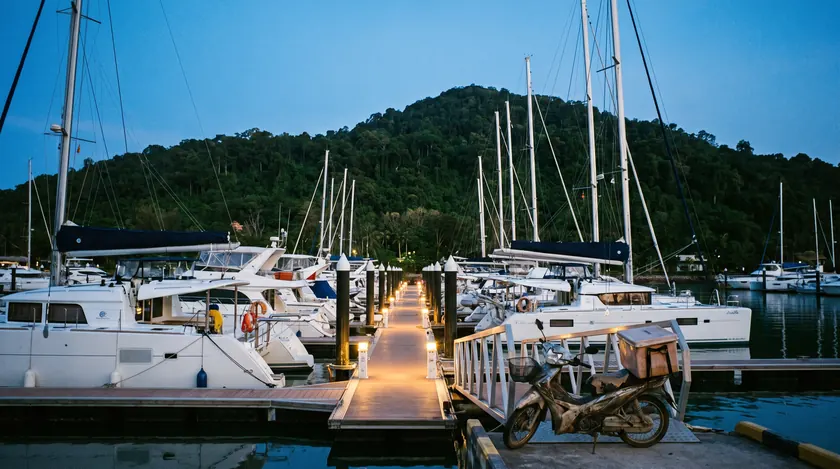 Used yachts for sale in a Phuket marina at dusk
